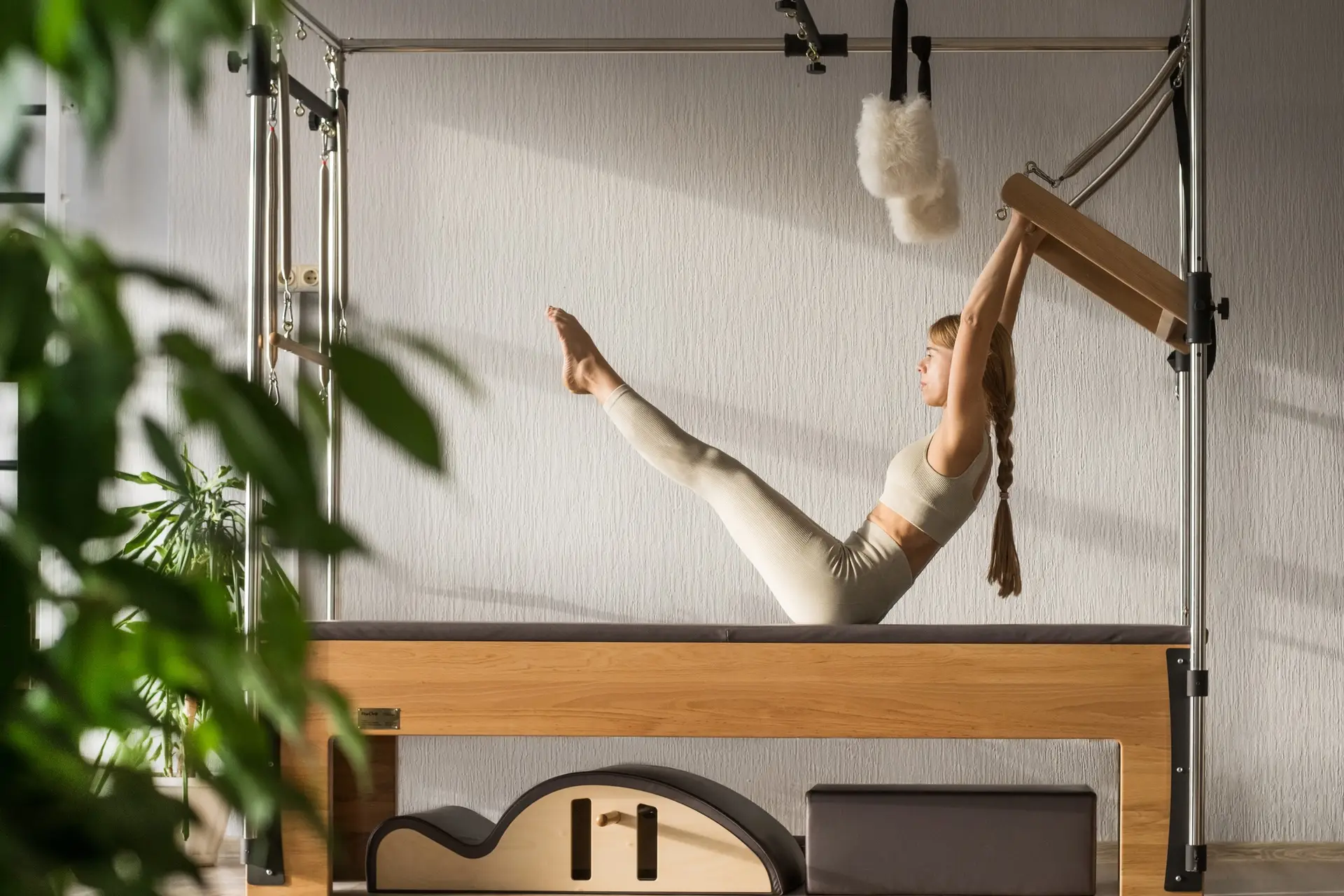 Pilates fitness trainer doing exercises on in pilates studio. Reformer pilates studio machine for
