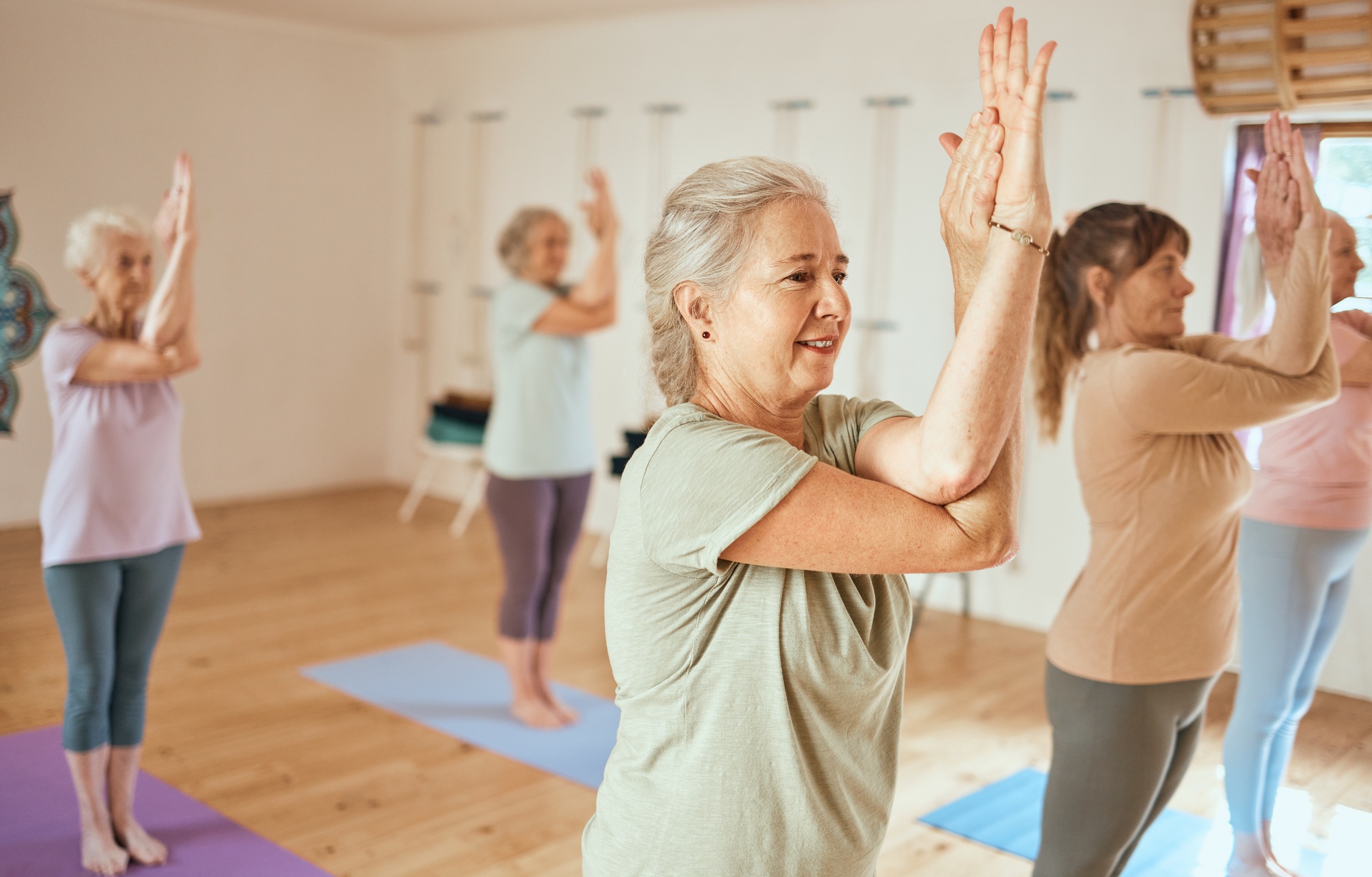 Pilates, wellness and group of senior women doing a mind, body and spiritual exercise in studio. He
