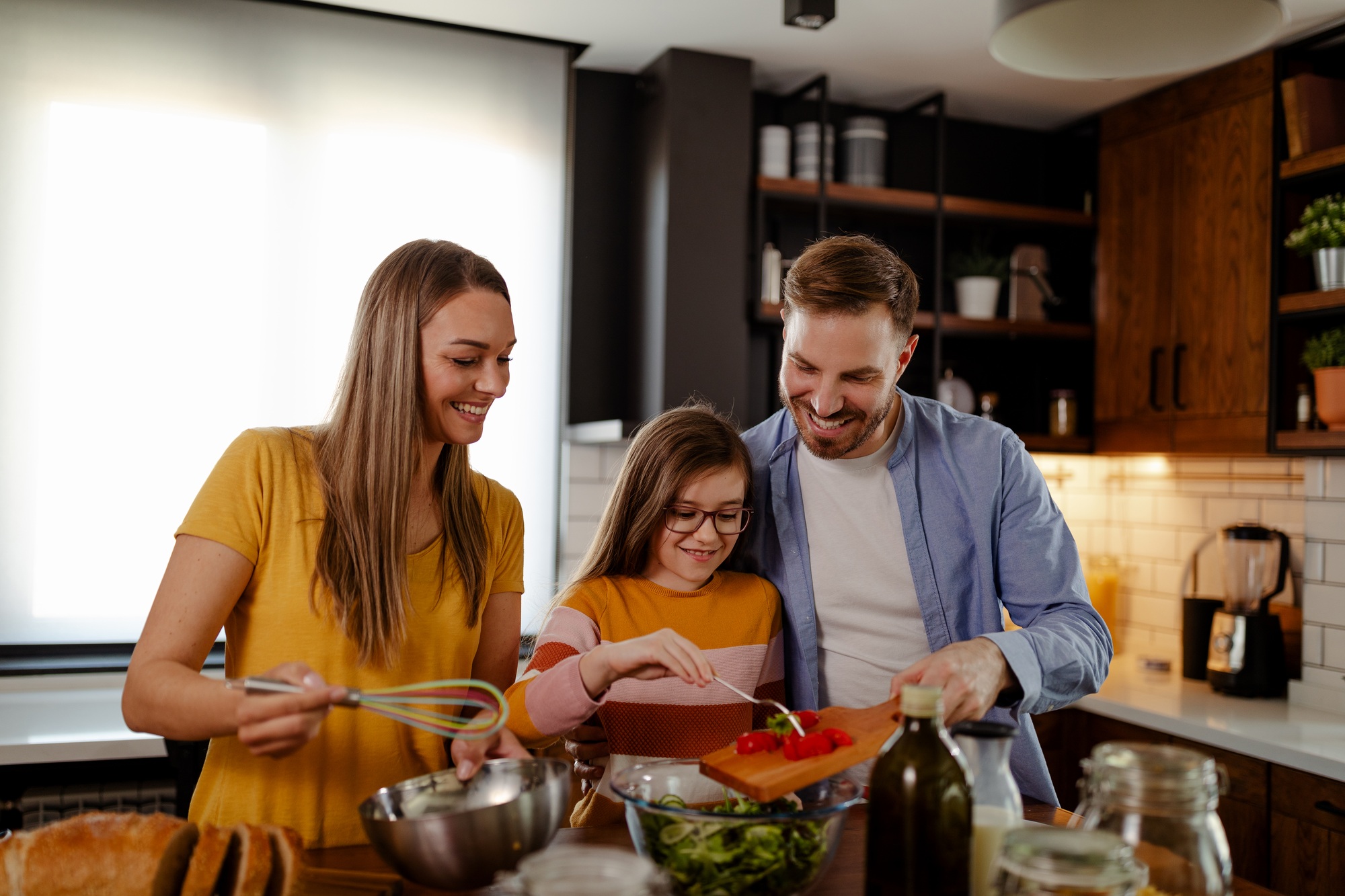 Dad, mom, and daughter time. Family is preparing a breakfast.