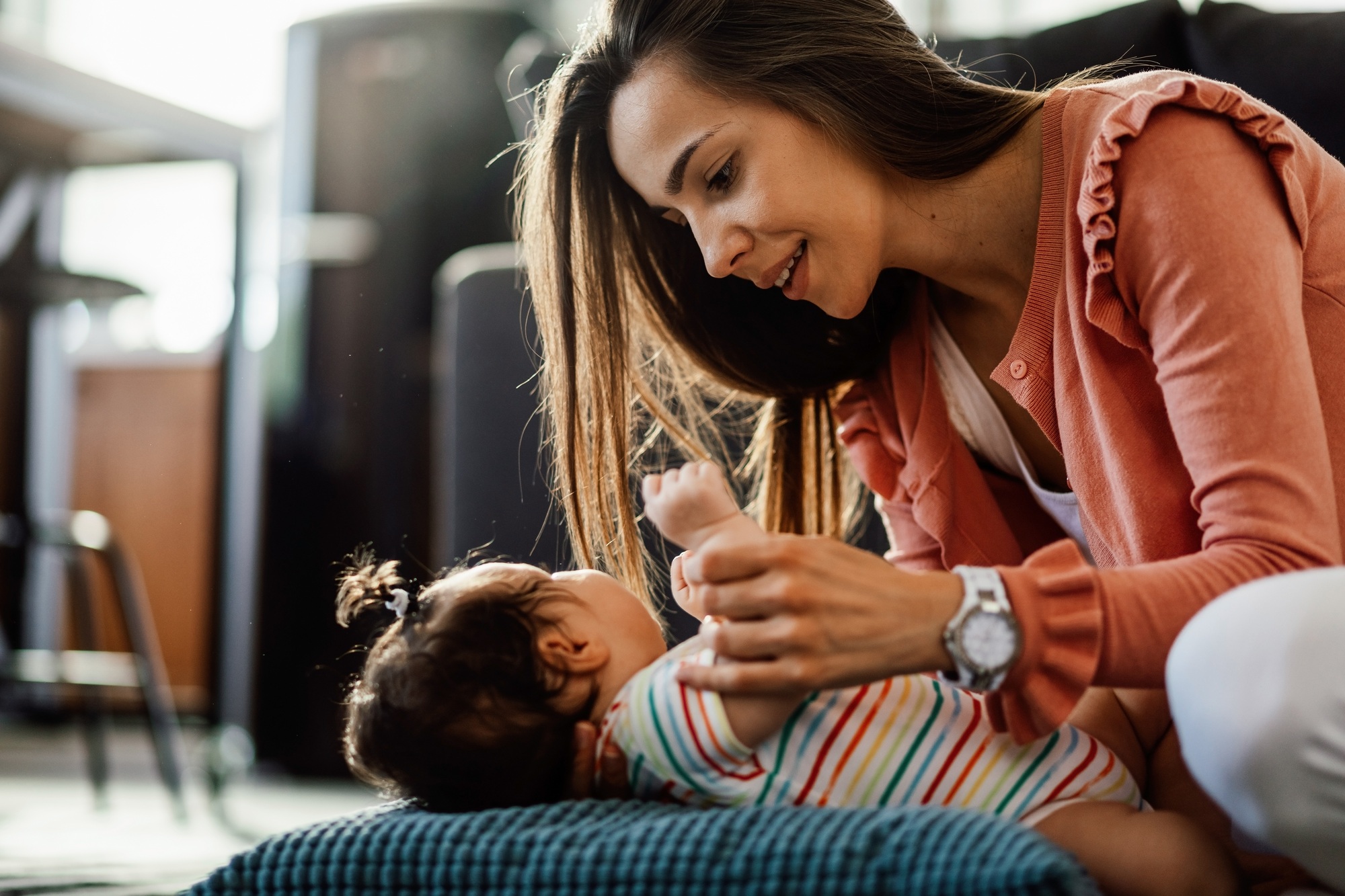 Young mother with her baby girl at home.