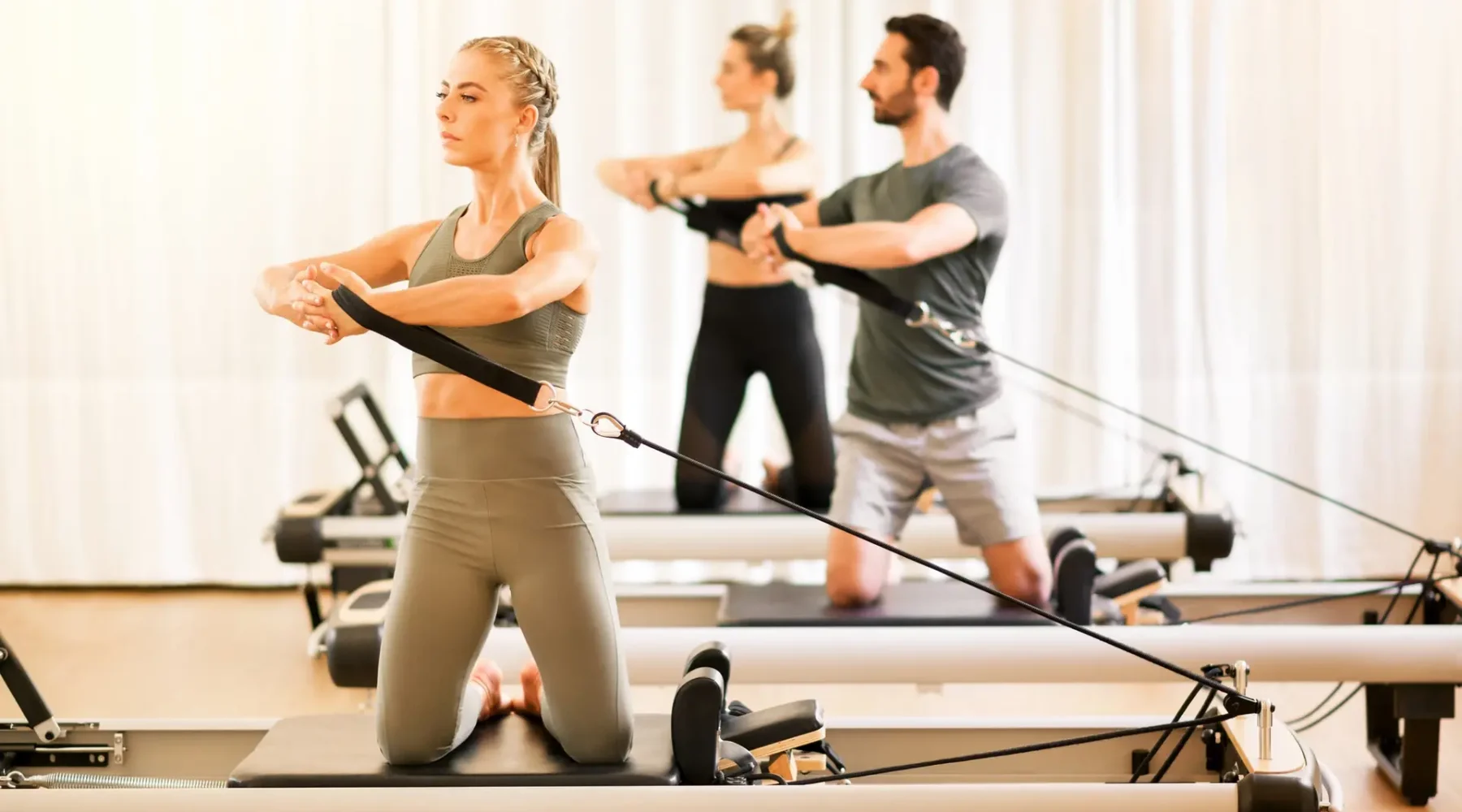 Group of people doing pilates torsion rotation exercises